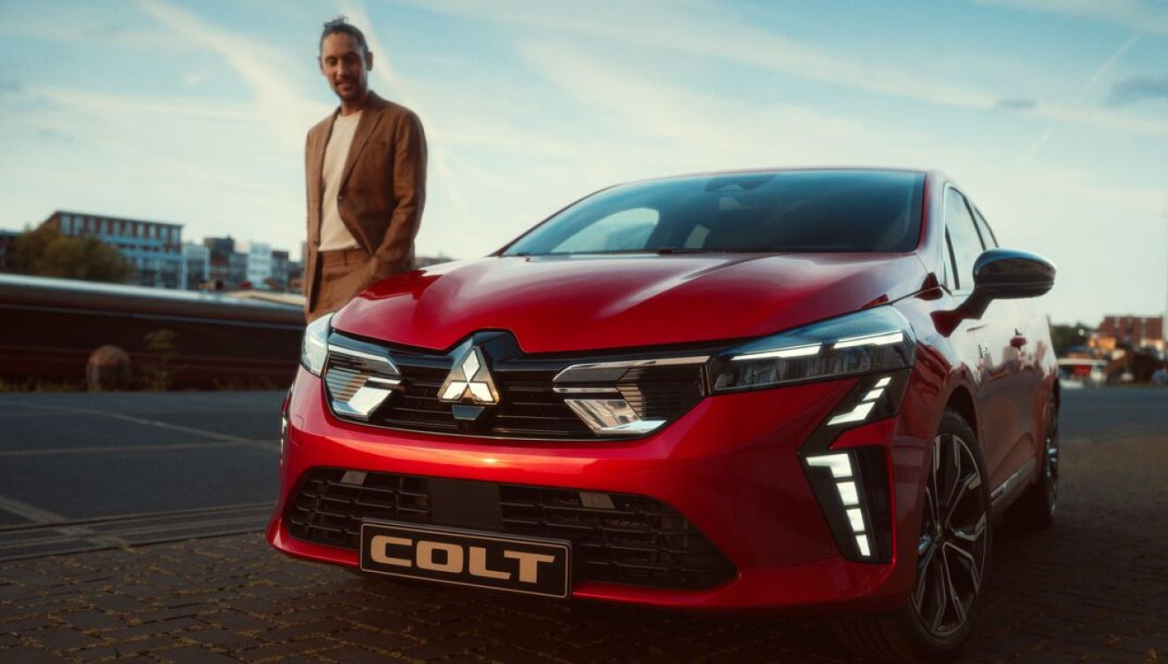 Homme à côté d'un véhicule Colt Mitsubishi qui présente les offres pour particuliers